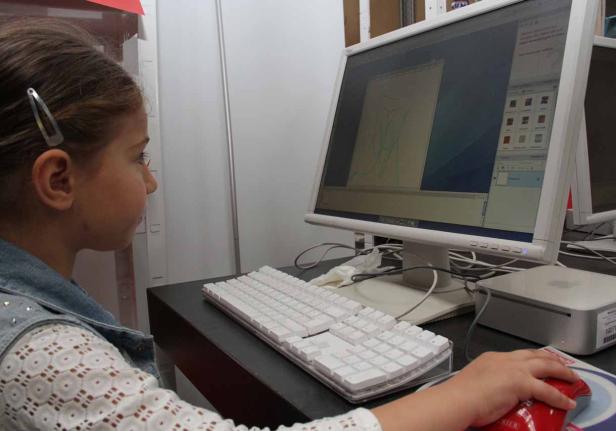 Ein junges Mädchen arbeitet an einem Computer mit einer Zeichenanwendung.