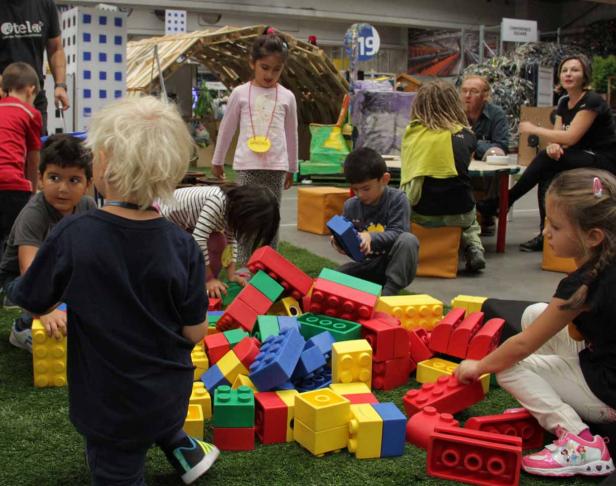 Eine Gruppe von Kindern spielt mit großen, bunten Bauklötzen.
