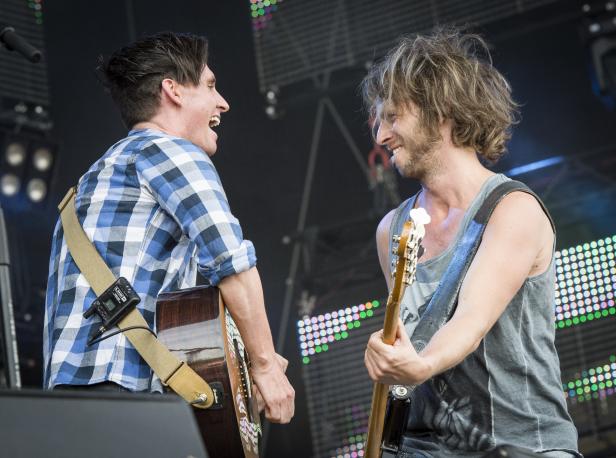 Zwei Musiker stehen auf der Bühne und spielen Gitarre.