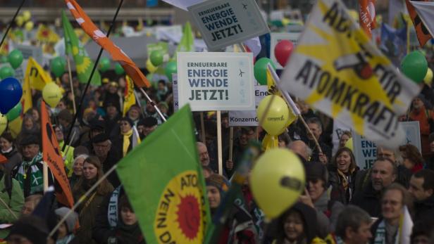 Eine Demonstration mit Schildern und Fahnen für erneuerbare Energien und gegen Atomkraft.