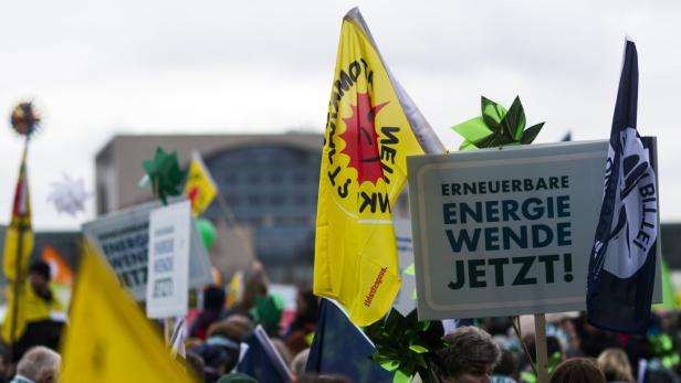 Demonstration für erneuerbare Energien mit Schildern und Fahnen im öffentlichen Raum.