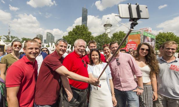 Eine Gruppe von Menschen macht ein Selfie mit dem DC Tower im Hintergrund.