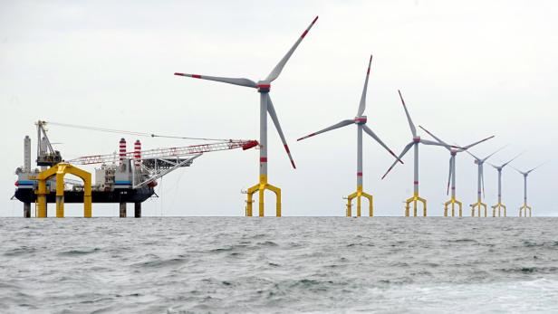 Eine Offshore-Windkraftanlage und ein Installationsschiff auf dem Meer.