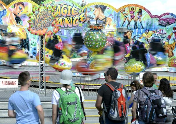 Besucher beobachten ein sich schnell drehendes Fahrgeschäft namens „Magic Dance“.