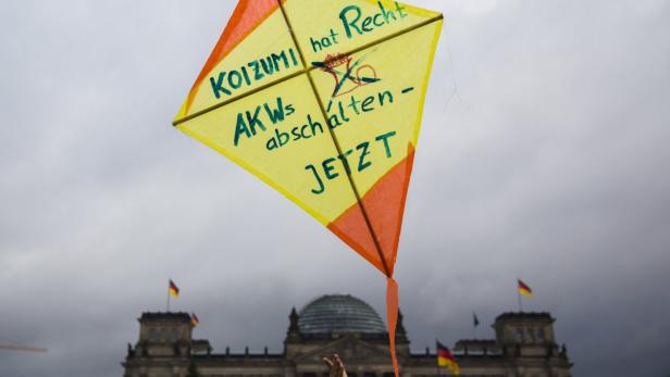 Ein gelber Drachen mit der Aufschrift „Koizumi hat Recht – AKWs abschalten – JETZT“ vor dem Reichstagsgebäude.
