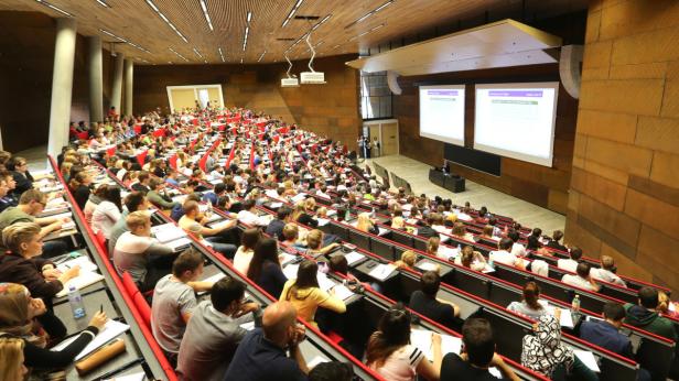 Ein voll besetzter Hörsaal mit Studierenden während einer Vorlesung.