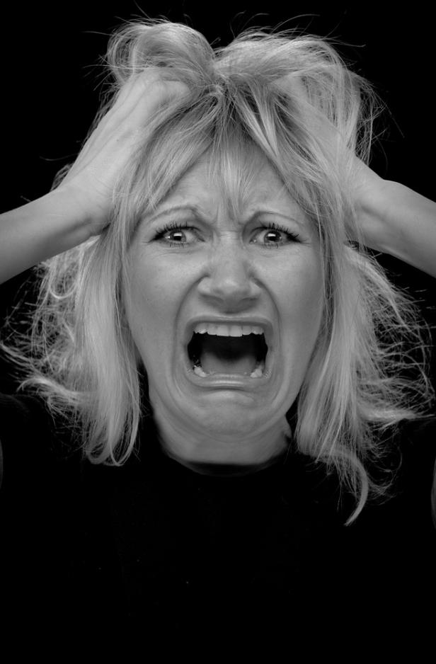 Eine Frau schreit verzweifelt und rauft sich die Haare.