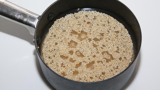 Amarant wird in einem Topf mit Wasser gekocht.