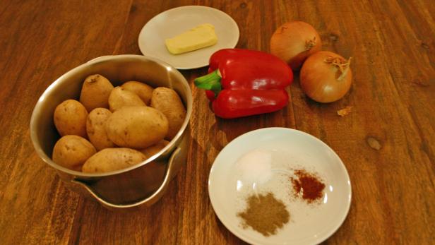 Zutaten für ein Gericht: Kartoffeln, Paprika, Zwiebeln, Butter und Gewürze.