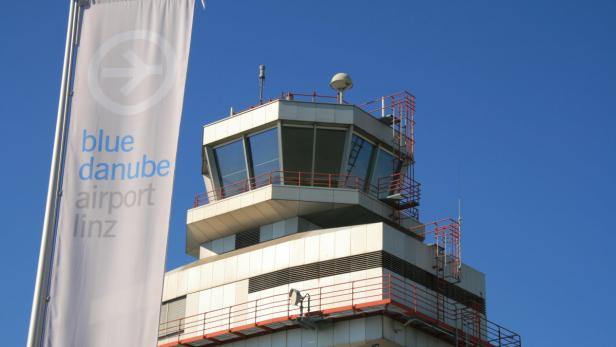 Der Kontrollturm des Blue Danube Airport Linz vor blauem Himmel.