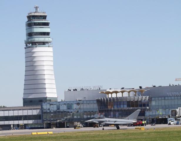 Ein Eurofighter steht vor dem Kontrollturm des Flughafens Wien.