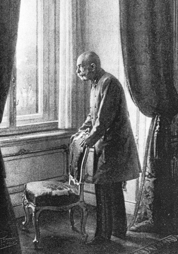 Ein älterer Mann mit Uniform steht am Fenster und blickt nach draußen.