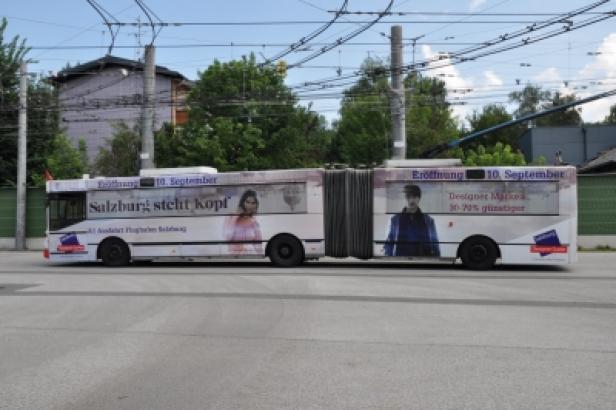 McArthur Glen Designer Outlet Salzburg Eröffnungskampagne/Fessler.Schmidbauer Ein Trolleybus in Salzburg mit Werbung für die Eröffnung eines Geschäfts am 10. September.