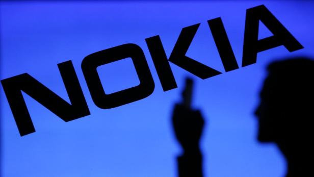 Das Nokia-Logo vor einem blauen Hintergrund, mit der Silhouette einer Person im Vordergrund.