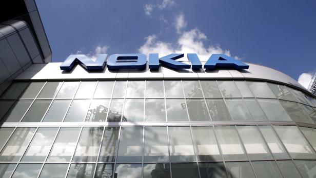 Das Nokia-Logo an einem modernen Bürogebäude unter blauem Himmel.
