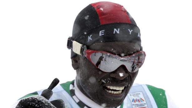 Ein kenianischer Skilangläufer mit Skibrille lächelt im Schnee.