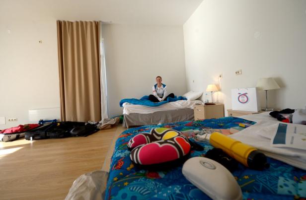 Eine Frau sitzt auf einem Bett in einem Hotelzimmer.