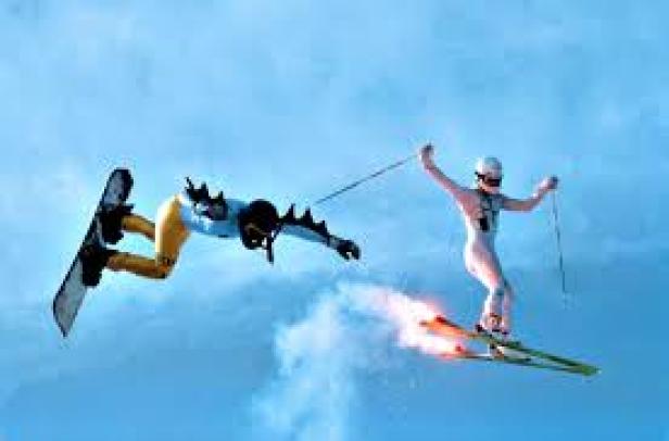 Ein Snowboarder wird von einem Skifahrer mit Raketenantrieb durch die Luft gezogen.