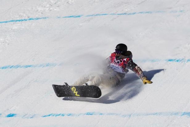 Ein Snowboarder stürzt auf einer schneebedeckten Piste.