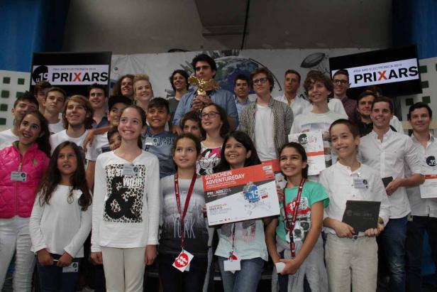 Eine Gruppe Jugendlicher posiert mit Urkunden und einem goldenen Preis für den Prix Ars Electronica 2015.