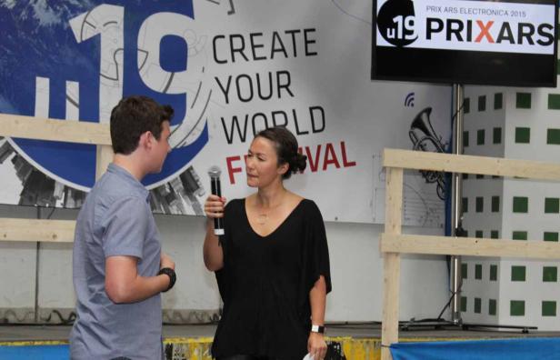 Eine Frau spricht bei einem „Create Your World“-Festival in ein Mikrofon.