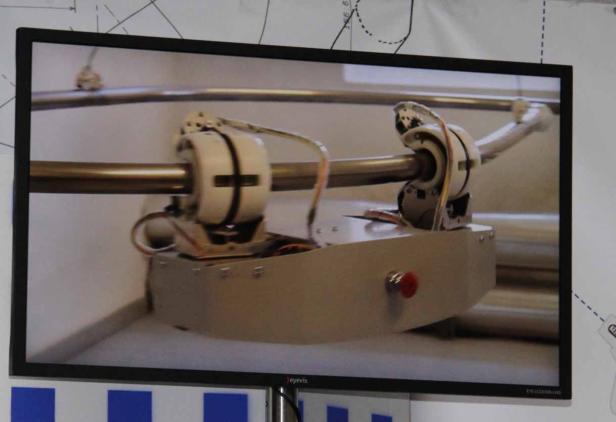 Ein Bildschirm zeigt eine Vorrichtung mit zwei rotierenden Elementen auf einer Metallschiene.