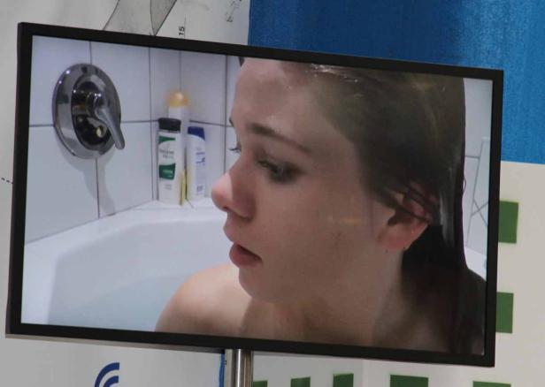 Eine Frau sitzt in einer Badewanne.