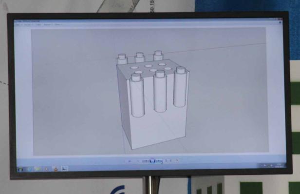 Auf dem Bildschirm ist eine 3D-Modellierung eines Objekts mit zylindrischen Elementen zu sehen.