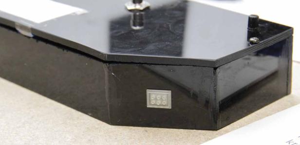 Eine schwarze Box mit einem Knopf und einer LED-Anzeige.