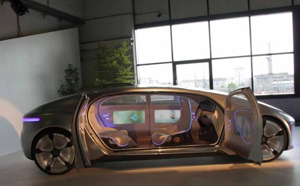 Ein futuristisches Auto mit geöffneter Tür steht in einem Ausstellungsraum.