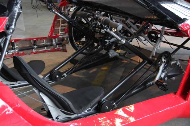 Das Innere eines roten Liegerads mit zwei Sitzen und Pedalantrieb.