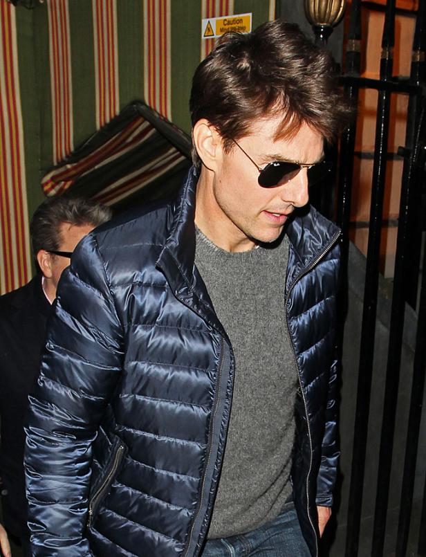 Tom Cruise trägt eine blaue Daunenjacke und eine Sonnenbrille.
