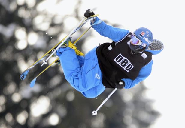 Ein Skifahrer in der Luft führt einen Trick vor.