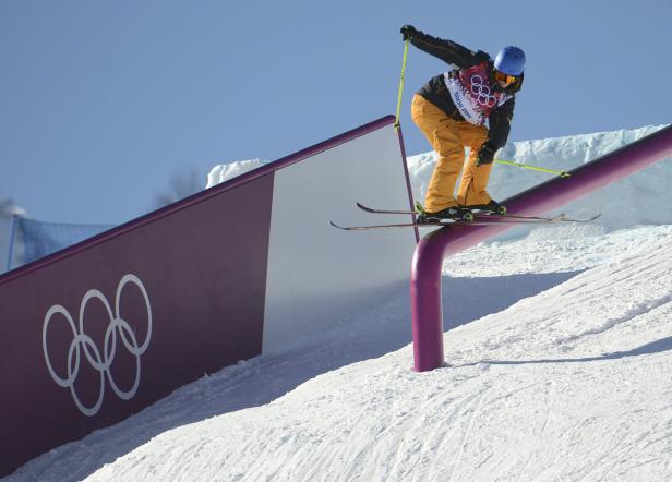 Ein Skifahrer fährt auf einer Rail bei einem Wettbewerb.