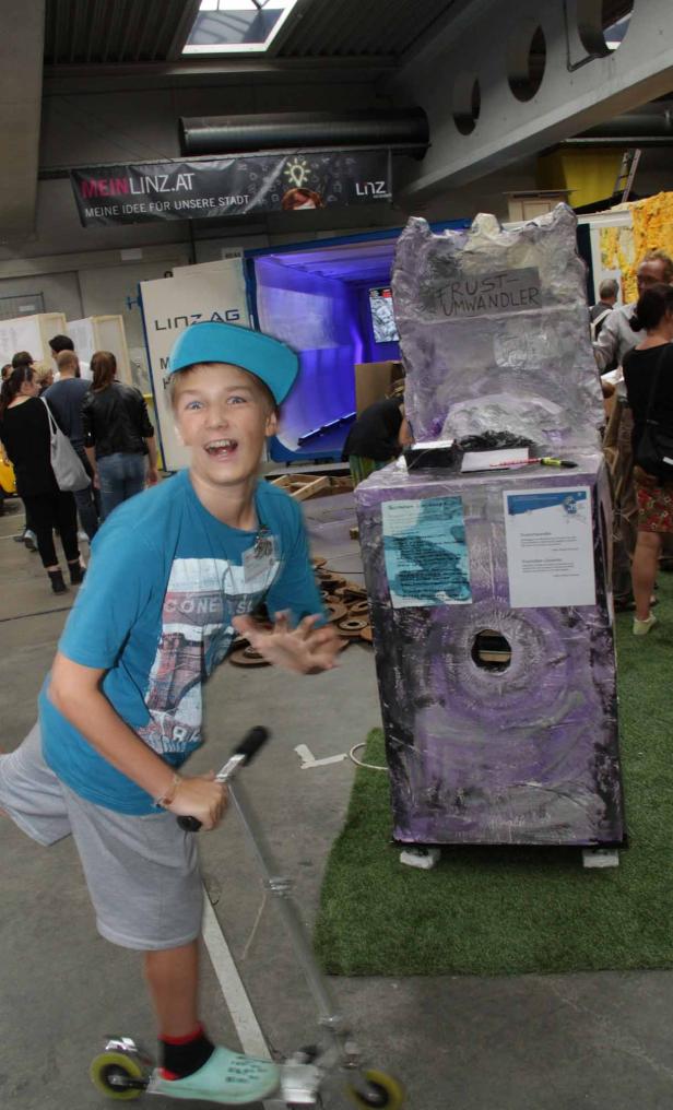 Ein Junge auf einem Roller vor einem „Frust-Umwandler“-Automaten.