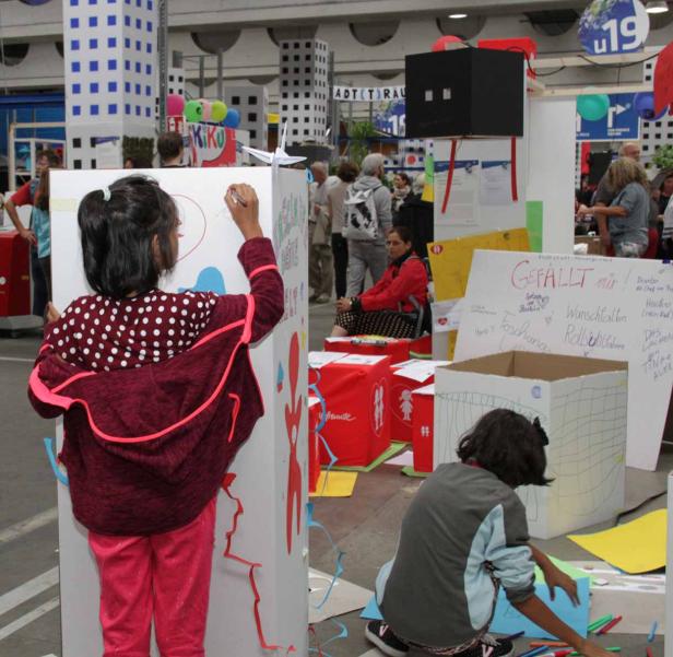 Zwei Mädchen gestalten einen Stand mit Herzen und Wünschen.