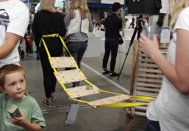 Eine Frau trägt eine Holzkonstruktion mit gelben Gurten um ihre Taille.