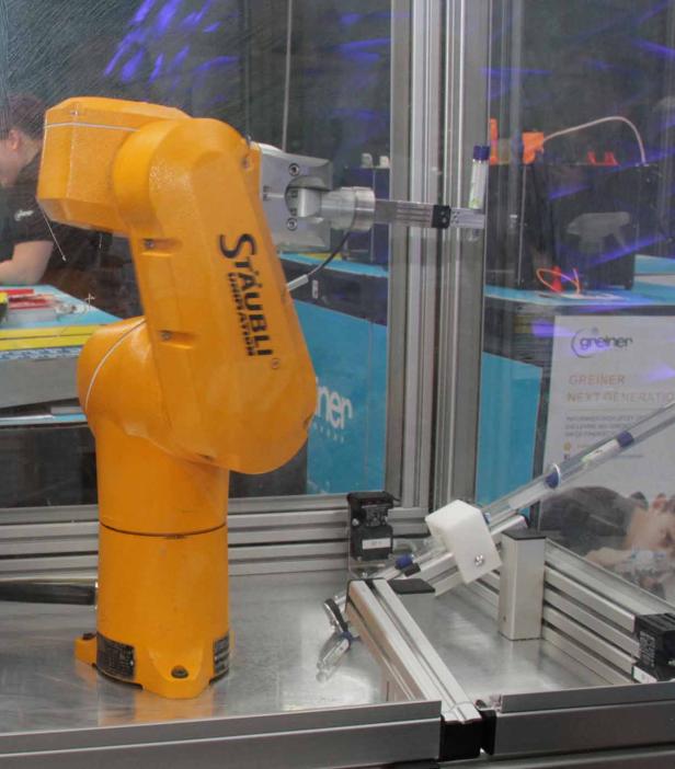 Ein gelber Industrieroboter der Marke Stäubli in einer Produktionsumgebung.