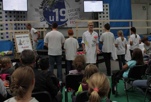 Zuschauer beobachten eine Aufführung auf einer Bühne während eines Festivals.