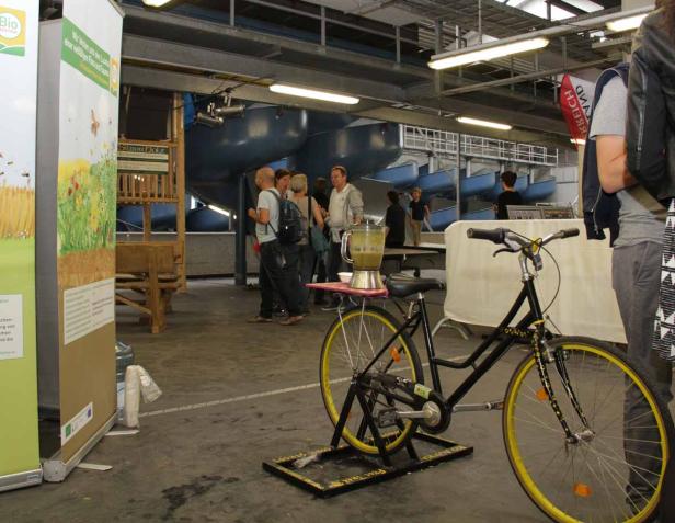 Ein Fahrrad betreibt einen Mixer mit einem grünen Smoothie auf einer Veranstaltung.