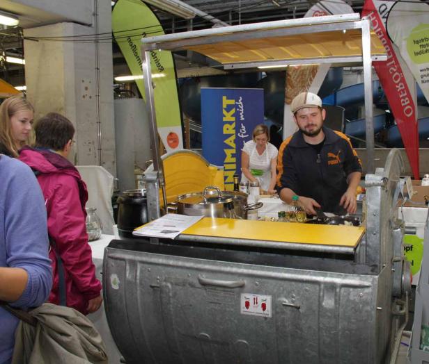Ein Mann kocht an einem Stand auf einem Markt.
