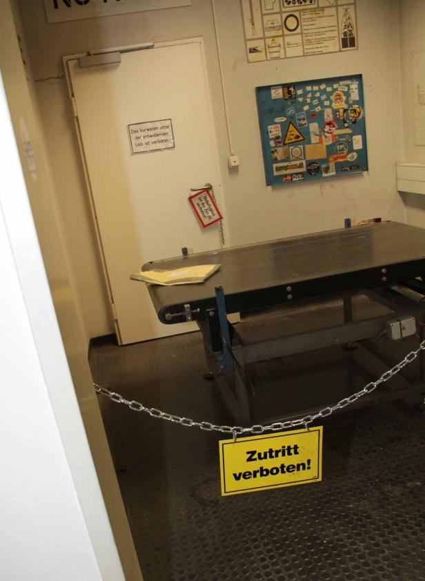 Ein Förderband ist mit einer Kette und einem „Zutritt verboten!“-Schild abgesperrt.