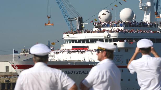 Das Kreuzfahrtschiff „Deutschland“, dekoriert mit Flaggen, liegt im Hafen.