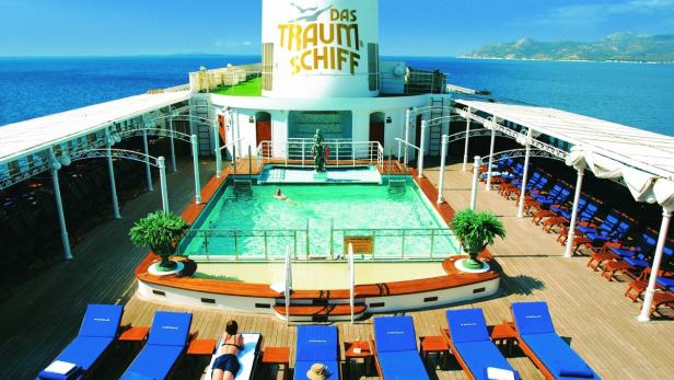 Blick auf das Pooldeck des „Traumschiffs“ mit Liegestühlen und Badegästen.