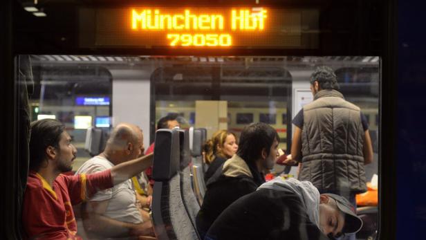 Fahrgäste sitzen in einem Zug, der am Münchner Hauptbahnhof abfährt.