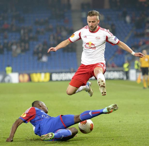 Zwei Fußballspieler kämpfen um den Ball auf dem Spielfeld.