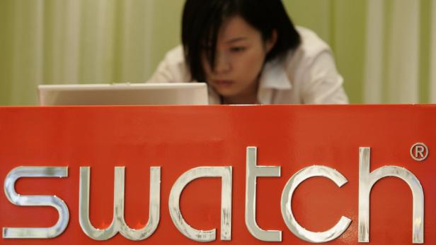 Eine Frau arbeitet hinter einem Tresen mit dem „Swatch“-Logo.