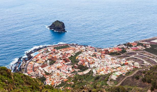 Blick auf Garachico, eine Stadt auf Teneriffa, mit einem kleinen Felseninselchen im Meer.