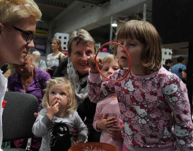 Eine Gruppe von Kindern und Erwachsenen spielt mit Seifenblasen.