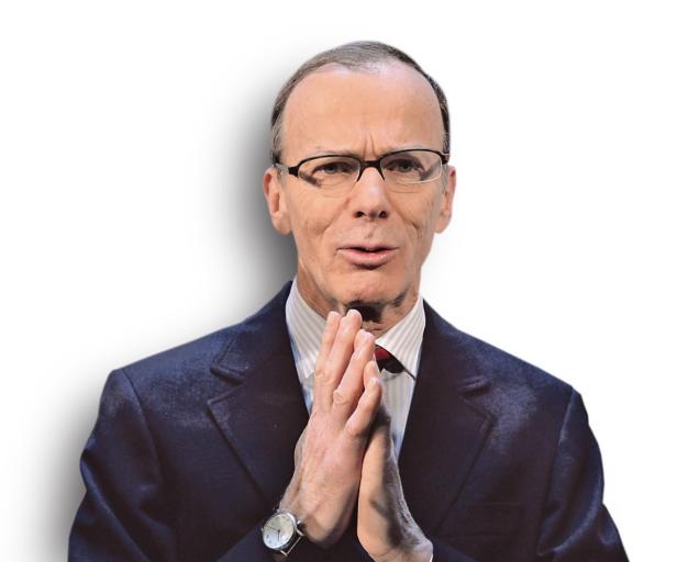 Ein Mann mit Brille und Anzug hält die Hände vor der Brust zusammen.